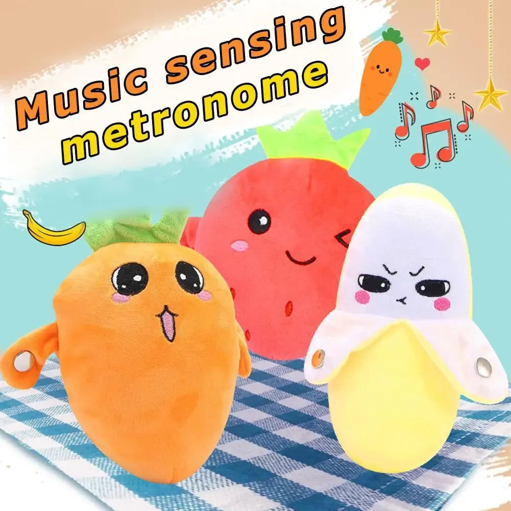 Drei musikalische, frucht-förmige Plüschtiere: eine Karotte, eine Erdbeere und eine Zitrone.