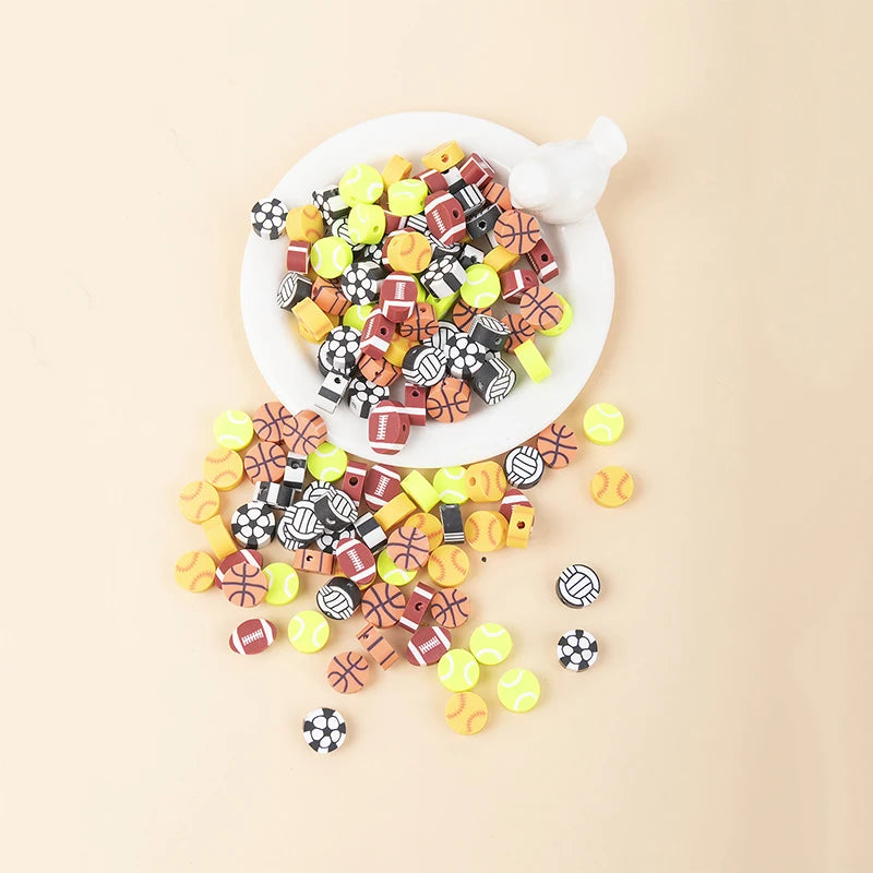 A pile of colorful polymer clay sport ball beads in various shapes and patterns is displayed on a white plate.