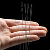 A hand holds a set of seven flexible bead threading needles for jewelry making