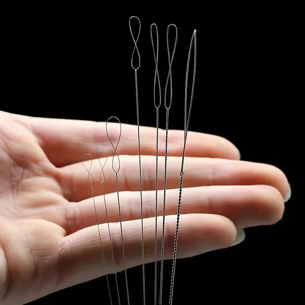 A hand holds a set of seven flexible bead threading needles for jewelry making
