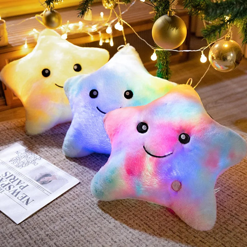 Three glowing star-shaped plush pillows with soft pastel colors are displayed under festive string lights.