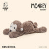 A soft, brown monkey plush toy is shown lying down against a light background.