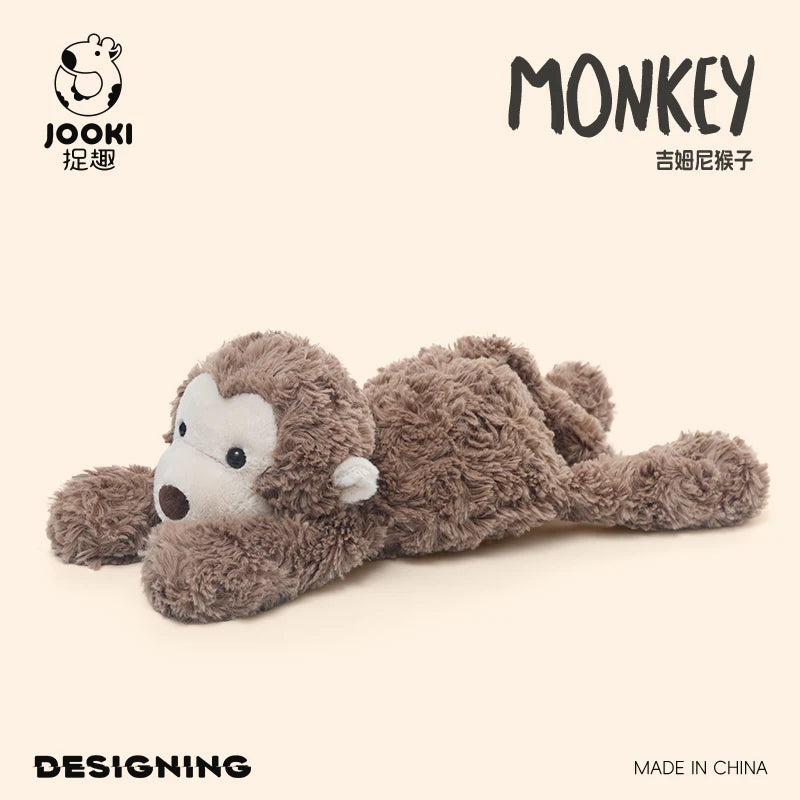 A soft, brown monkey plush toy is shown lying down against a light background.
