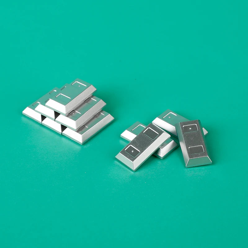 A collection of silver and gold building blocks resembling treasure chest coins on a teal surface.