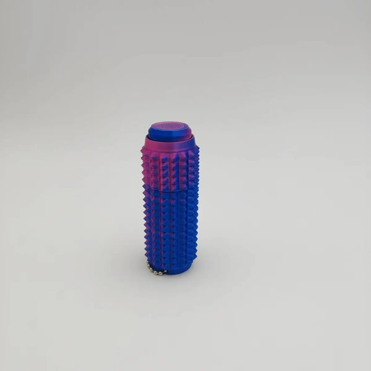 A vibrant purple and pink spiky fidget roller stress relief keychain.