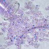 A scattering of purple and iridescent aurora cut glass beads for jewelry making.