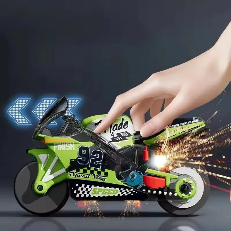 A hand is holding a green and black motorcycle keychain fidget toy with spinning wheels and sparks.