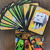 A stack of FLIP! matching cards featuring pixel art characters and numbers, including a special rule card.