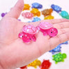 Pink glow in the dark mini turtle collectible figurines held in a hand with other colorful toys