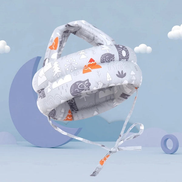 A white safety hat for toddlers featuring various woodland and nature-themed patterns, displayed against a light blue backgro