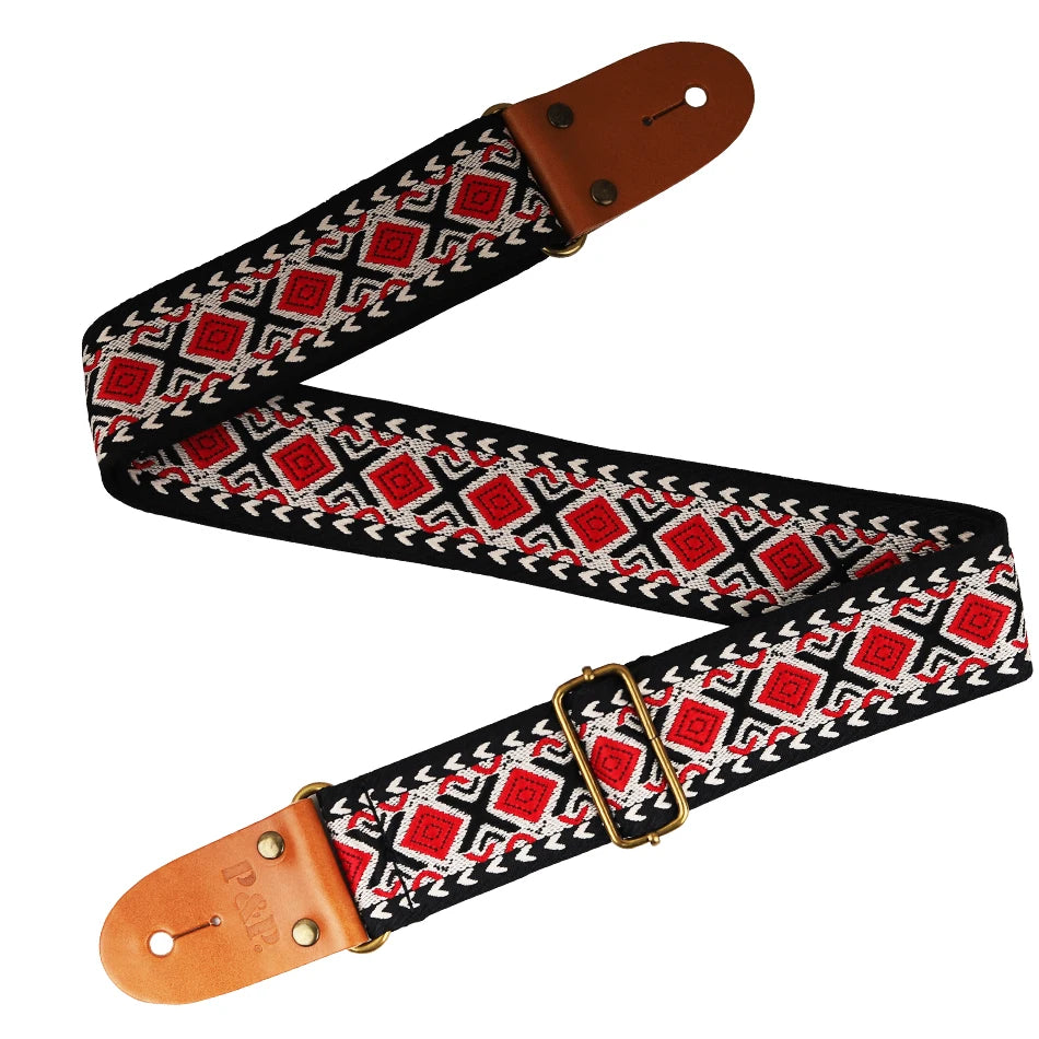 Embroidered guitar strap featuring a black and red geometric pattern with brown leather ends.
