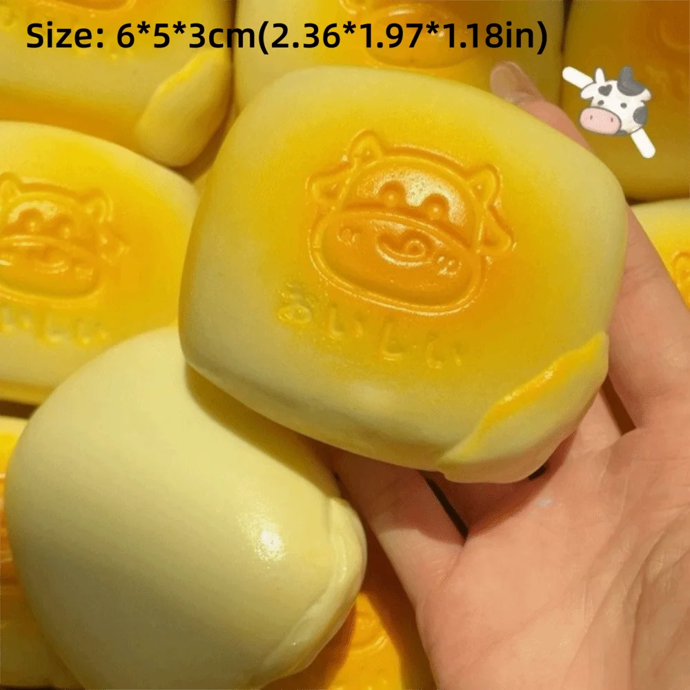 A hand holds a yellow squishy milk bread stress relief toy with an embossed face design.