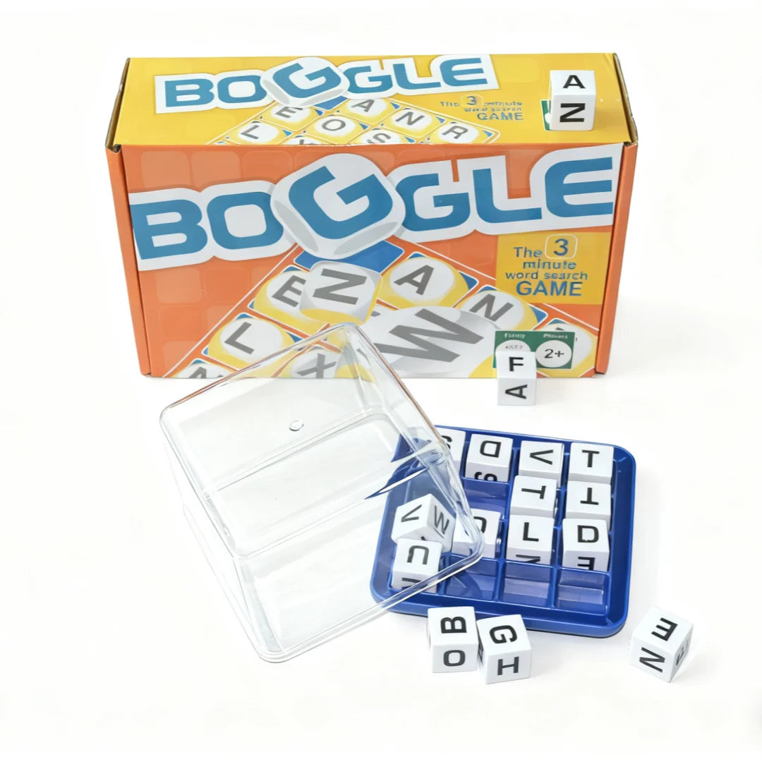 A box of Boggle dice game with a clear plastic container and several white wooden dice scattered on a white surface.