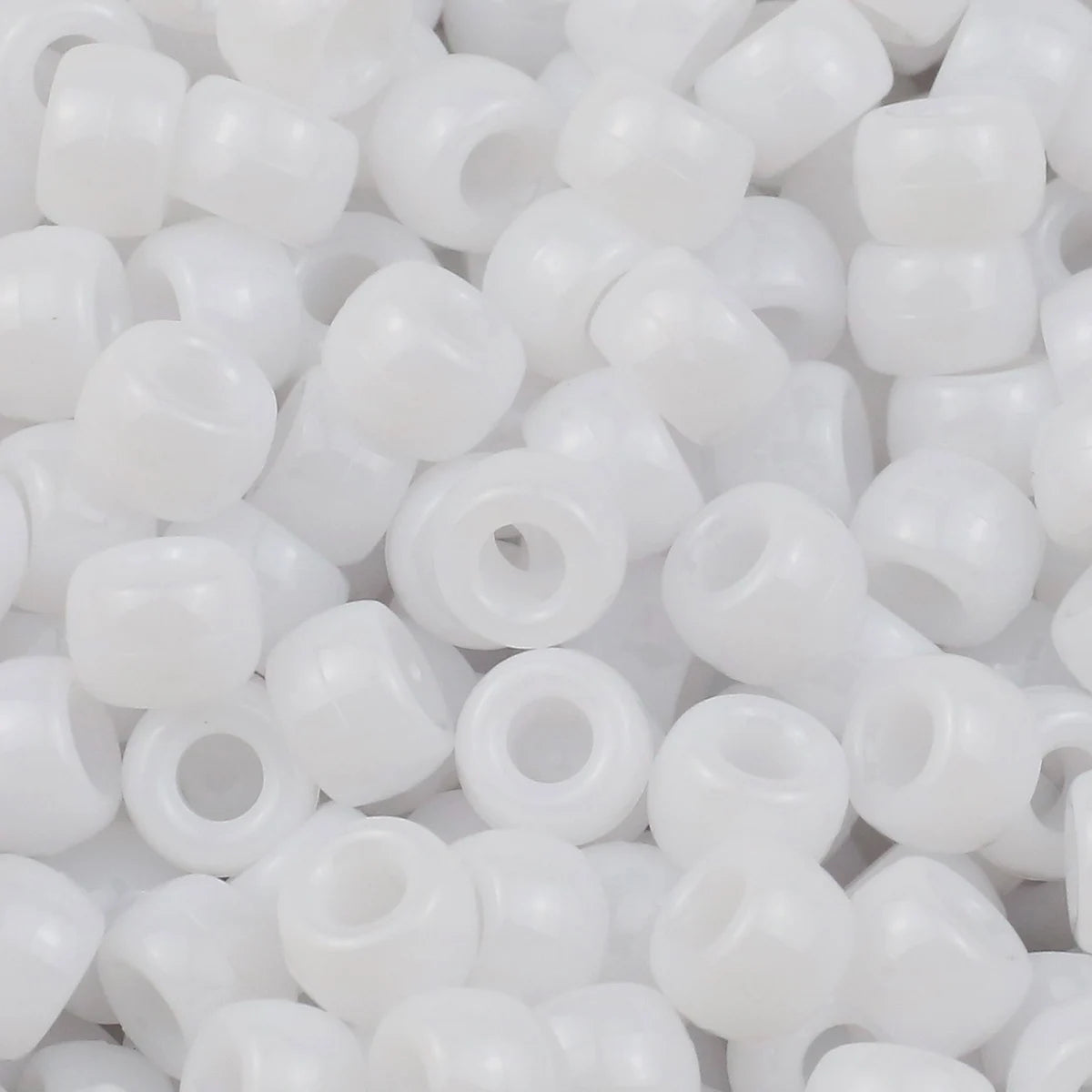 A pile of small, white pony beads for jewelry making and crafts.