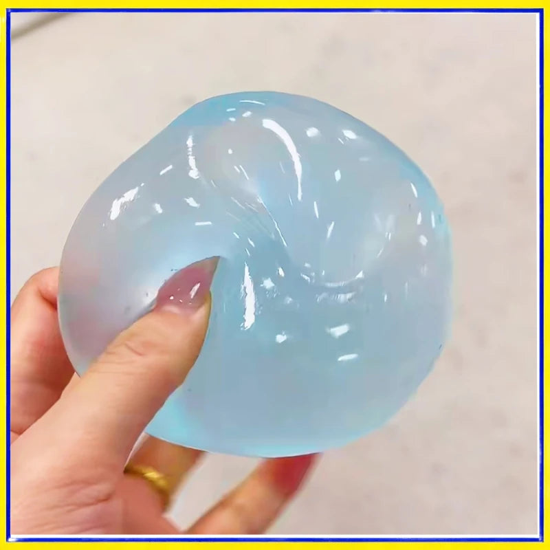 A hand is squeezing a translucent light blue coconut oil squishy stress relief ball.