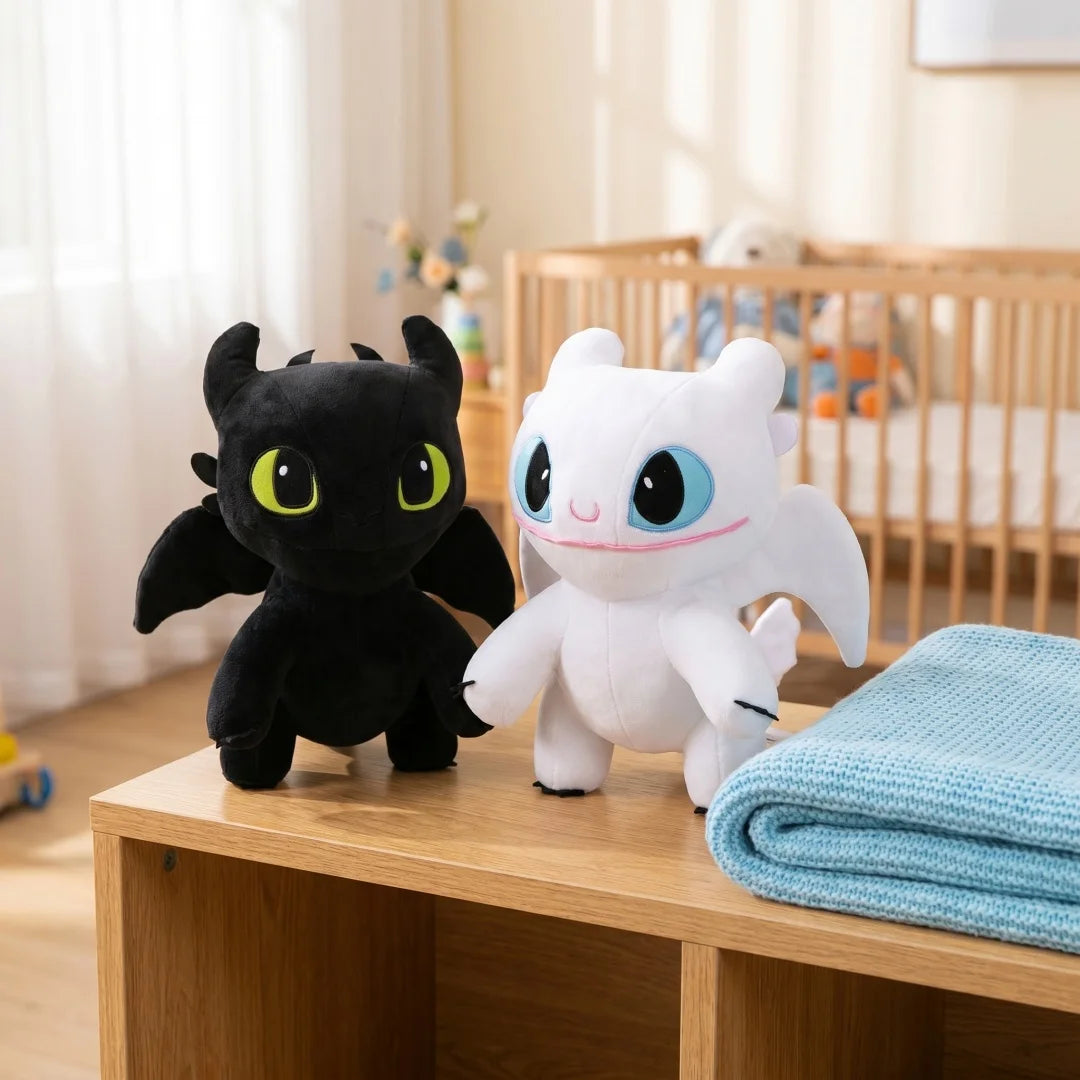 A black dragon plush toy next to a white cartoon animal plush on a wooden surface.