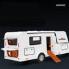 A white diecast metal RV camper truck model with an open door and steps on a dark background.