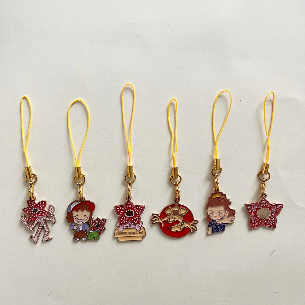 A set of six metal keychains featuring character pendants from Stranger Things.
