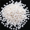 A pile of white polymer clay slices shaped like snowflakes.