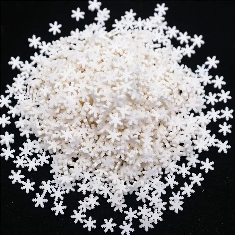 A pile of white polymer clay slices shaped like snowflakes.