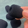 A hand holds a black replacement microphone foam cover for meeting microphones.