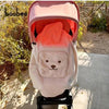 A pink baby windproof cape blanket with a white dinosaur design is displayed outdoors.