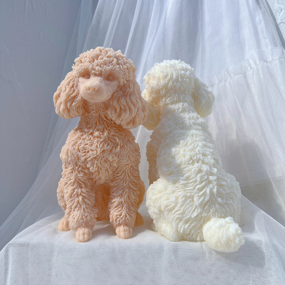 Two fluffy poodle dog silicone candle molds in peach and cream colors resting on white fabric.