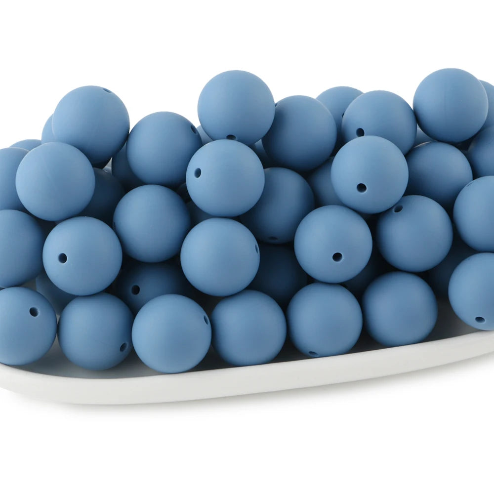 A pile of round, matte blue silicone beads for jewelry making and DIY crafts.