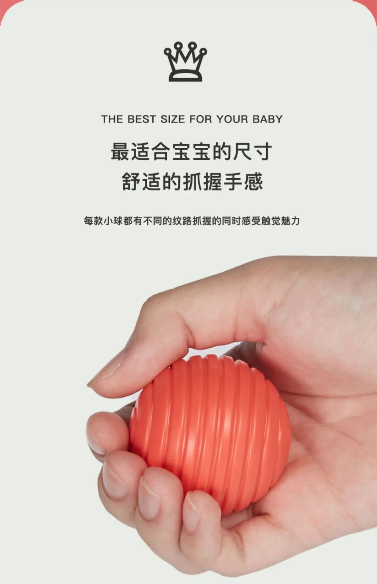A hand holds an orange Montessori shape sorting cube with elastic bands.