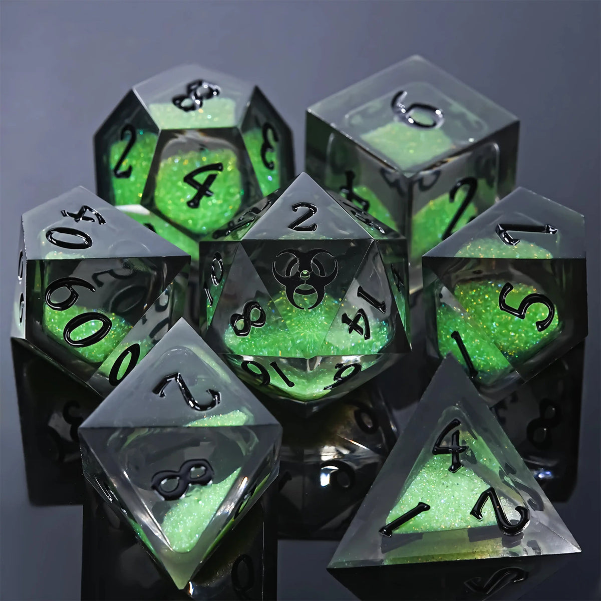 A stack of seven green liquid core resin polyhedral dice for tabletop role-playing games