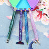 A set of five diamond painting pens with interchangeable metal tips and multi-placers in various colors resting on a light bl