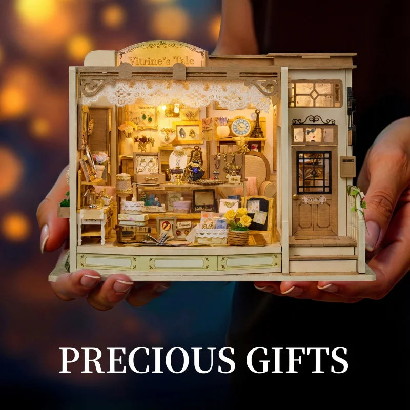A wooden miniature dollhouse kit of a jewelry store with various items and LED lights being held by a person.