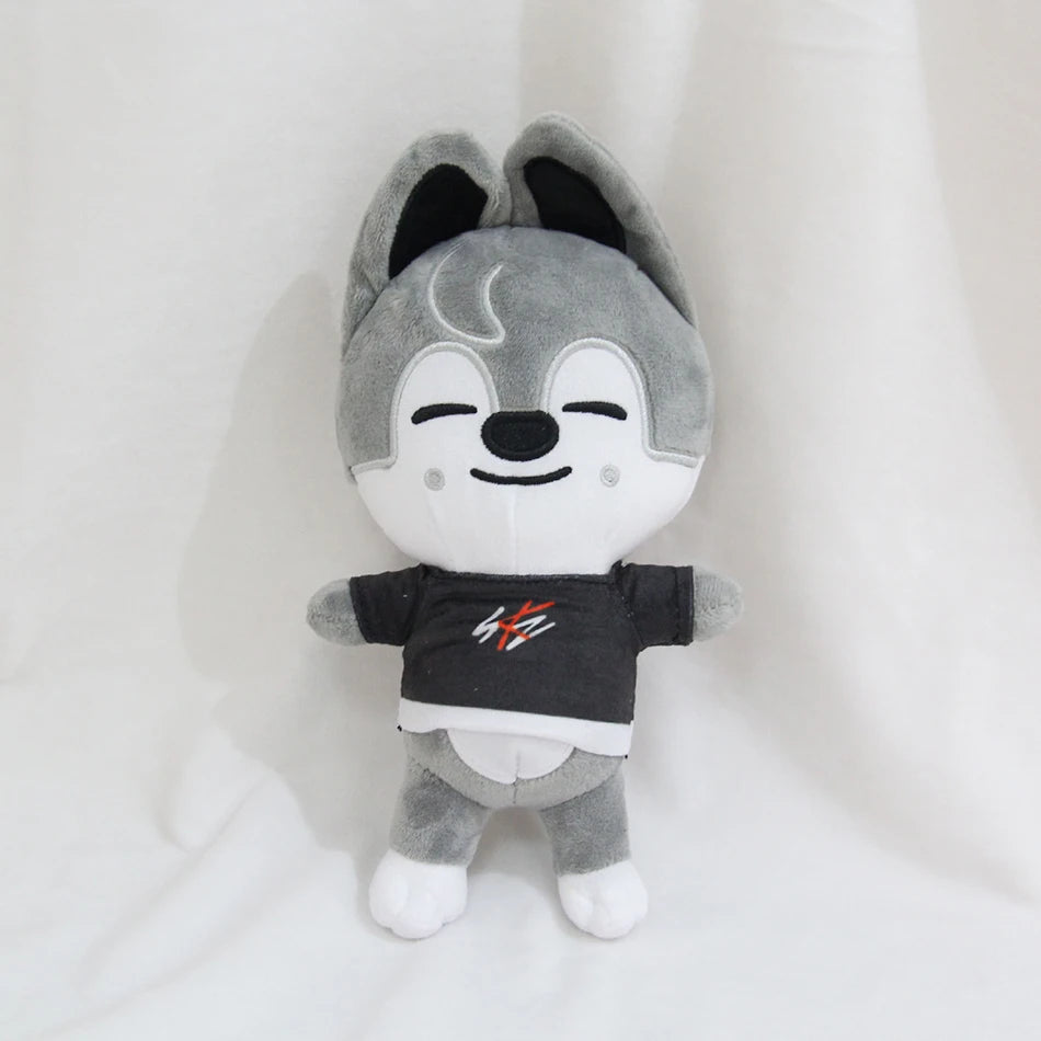 A gray and black cartoon animal plush toy with large ears and a black shirt featuring red and white graphics.