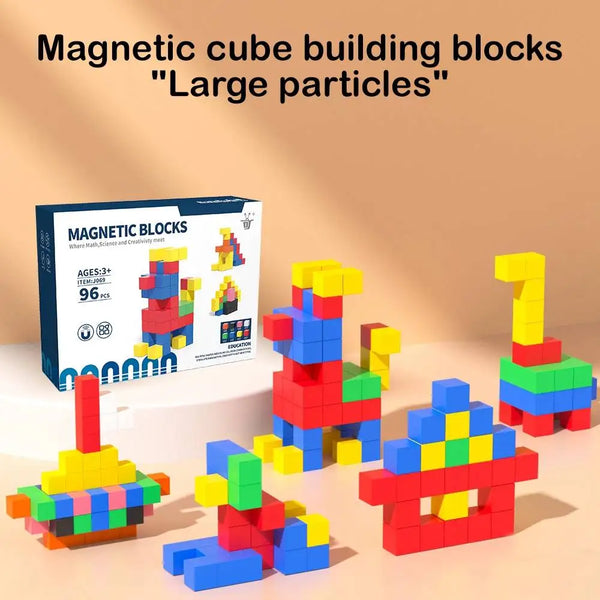 A collection of colorful magnetic cube building blocks in various sizes and colors scattered on a light surface.