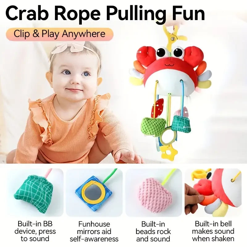 A baby is holding a crab-themed toy with a hanging strap, featuring a silicone rattle and teether.