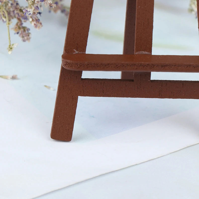 A small, rectangular wooden artist easel in a warm brown color resting on white paper.