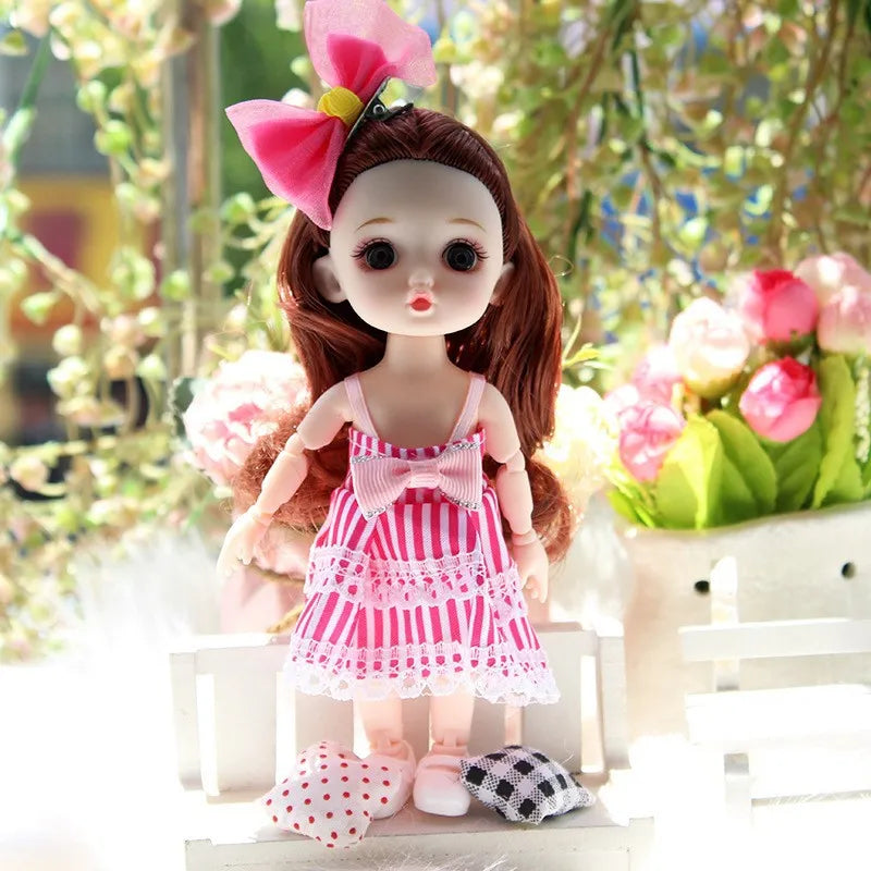 A 17cm articulated princess doll with long brown hair wearing a pink and white striped dress and a large pink bow.