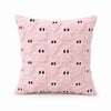 A pink fuzzy pillow with black ghost patterns.