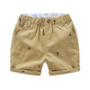 Tan cotton beach shorts for boys featuring a repeating anchor print