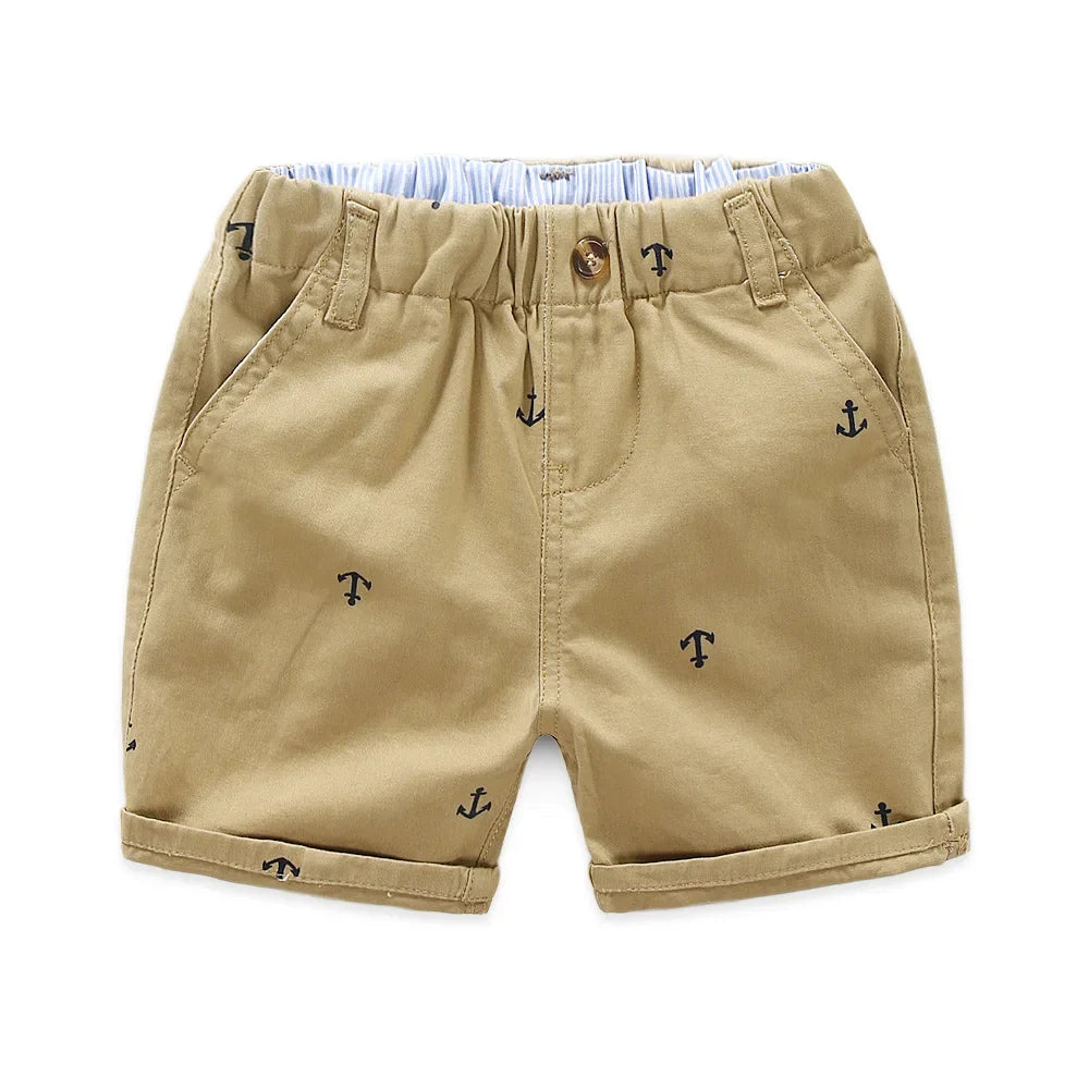 Tan cotton beach shorts for boys featuring a repeating anchor print