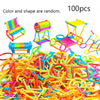 A pile of colorful wooden stick building blocks and colorful plastic toys, including a rainbow-colored chair and a yellow pla