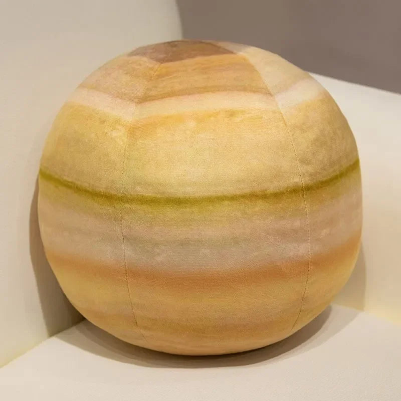 A spherical plush toy depicting an orange and yellow striped planet, resembling a solar system model.