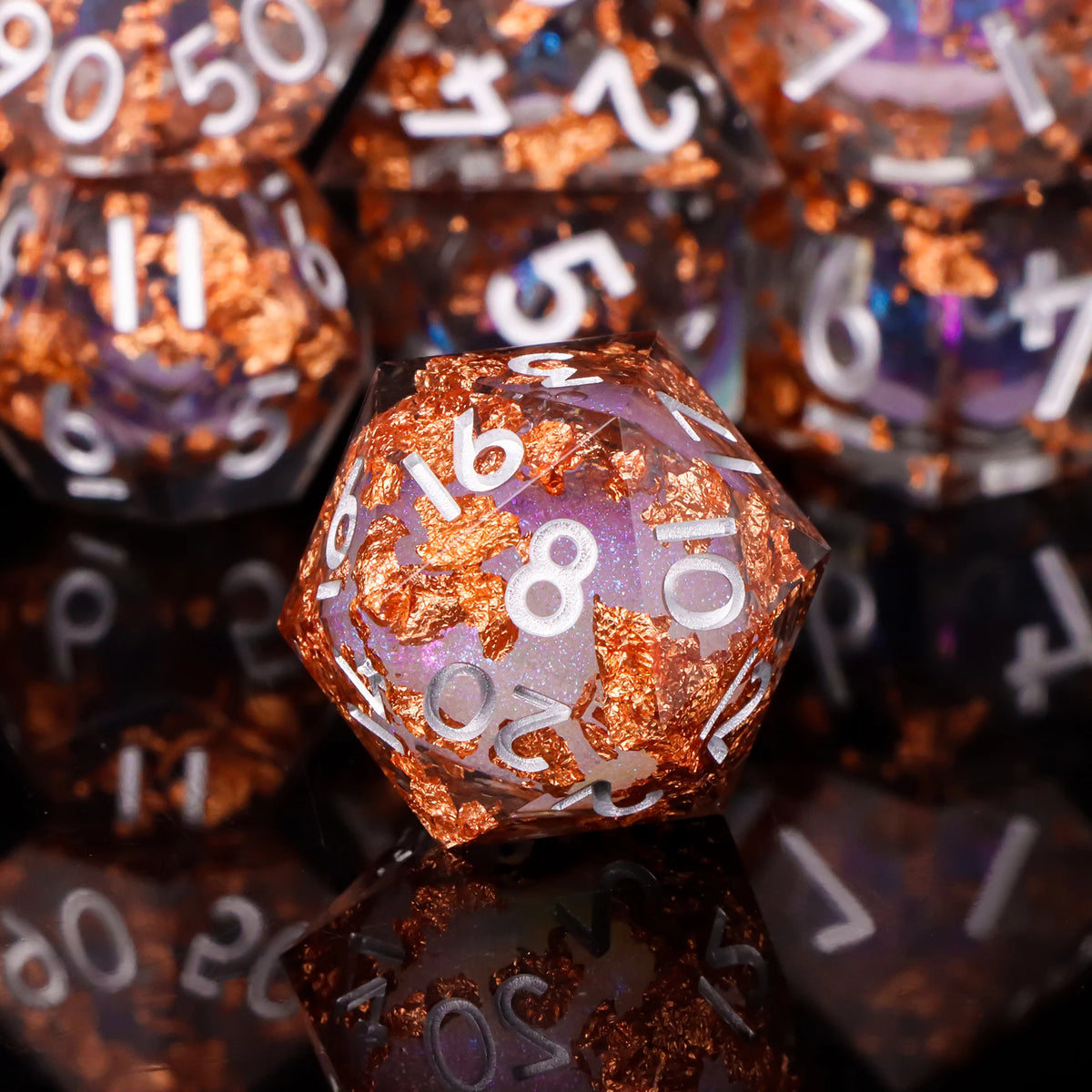 A close-up of a set of polyhedral dice with a shimmering copper and purple finish, resting on a dark surface.