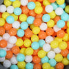 A bulk set of colorful plastic ocean ball pit toys in various shades of orange, yellow, and blue.