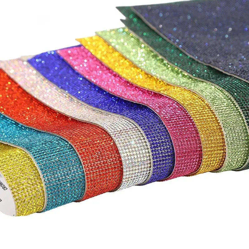 A collection of colorful sparkling rhinestone adhesive tape rolls in various shades and glitter textures.
