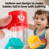 A baby is playing with colorful plastic stacking cups, including a red pouring cup and a yellow cup.