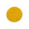 A bowl filled with loose, round, yellow Czech glass seed beads for jewelry making.