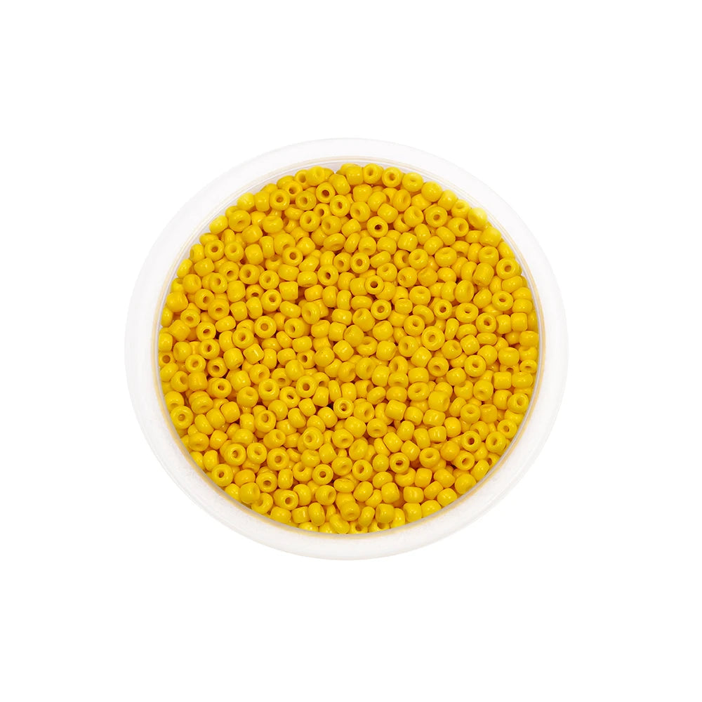 A bowl filled with loose, round, yellow Czech glass seed beads for jewelry making.