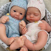 Two newborn silicone reborn dolls wearing knitted hats and outfits sitting in a woven basket