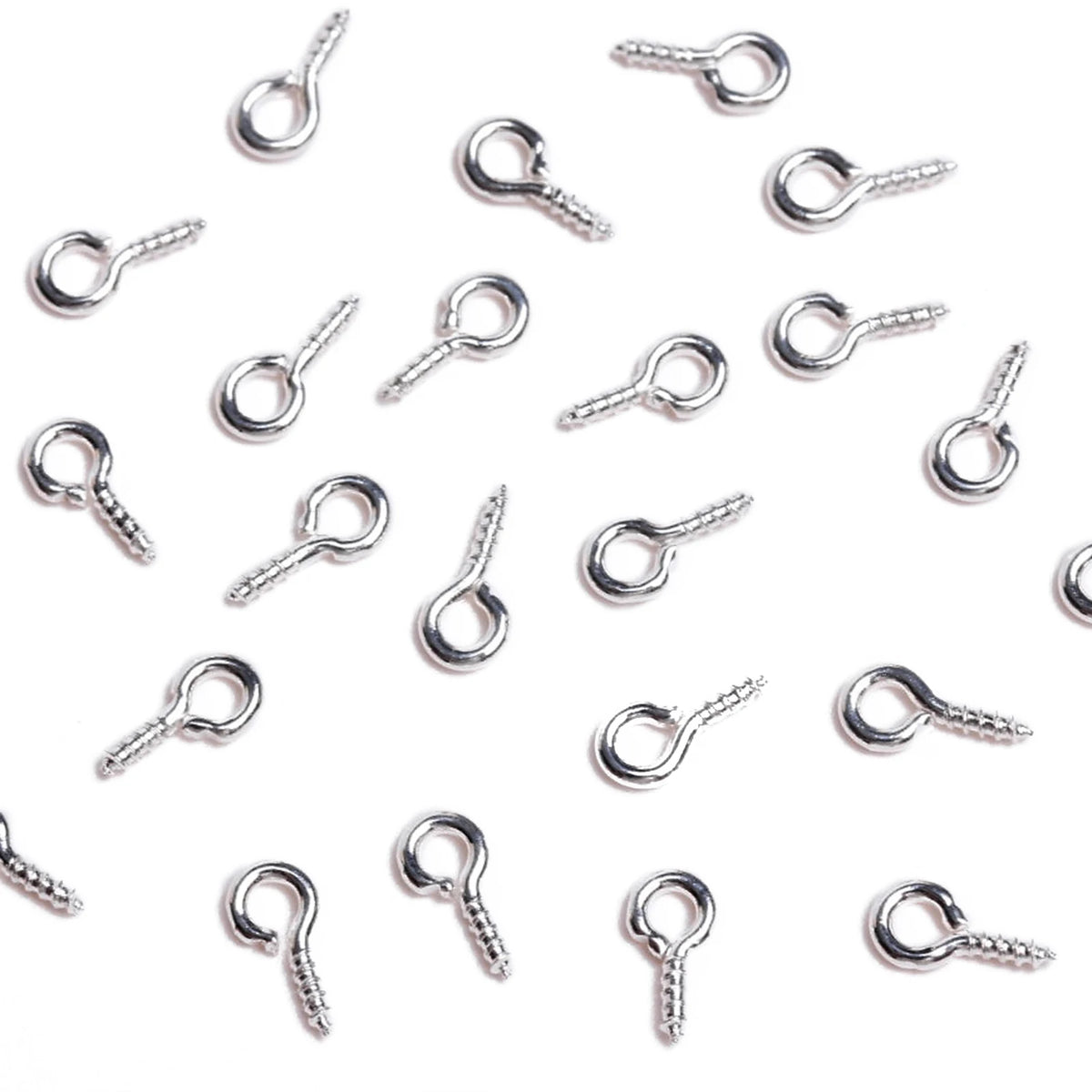 A collection of silver metal eye pins used for jewelry making and DIY crafts.